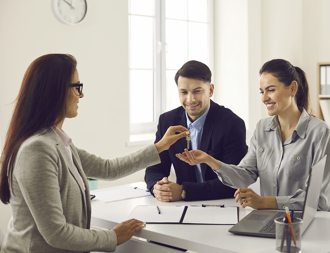 Agent handing keys to happy couple